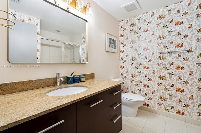 bathroom with vanity, toilet, tile patterned floors, and walk in shower