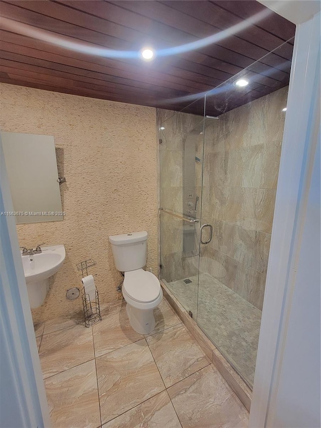 bathroom with walk in shower, toilet, and sink