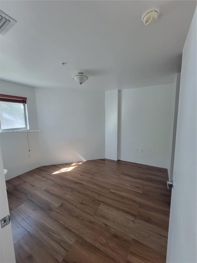 unfurnished room featuring dark wood-type flooring