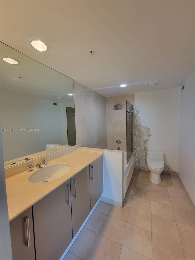 full bathroom featuring vanity, toilet, tiled shower / bath combo, and tile patterned flooring