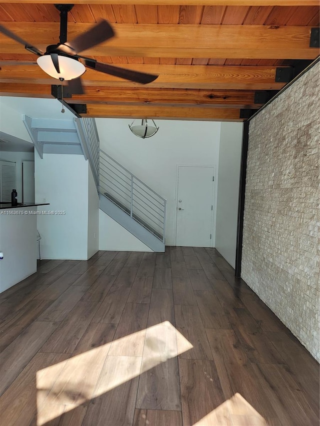 unfurnished living room featuring beam ceiling, wood ceiling, and dark wood-type flooring