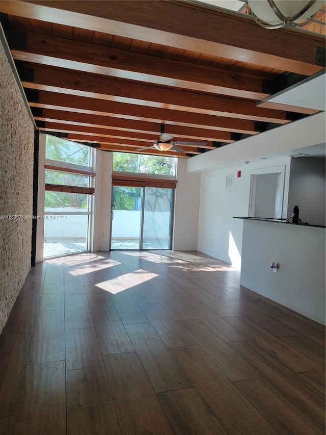 unfurnished room featuring dark hardwood / wood-style flooring, ceiling fan, and beamed ceiling