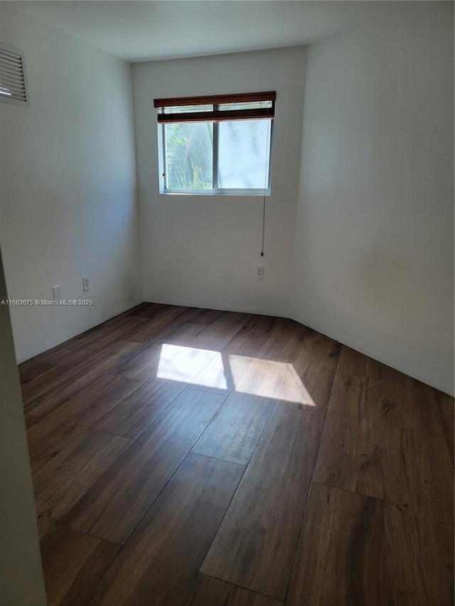 spare room featuring dark wood-type flooring