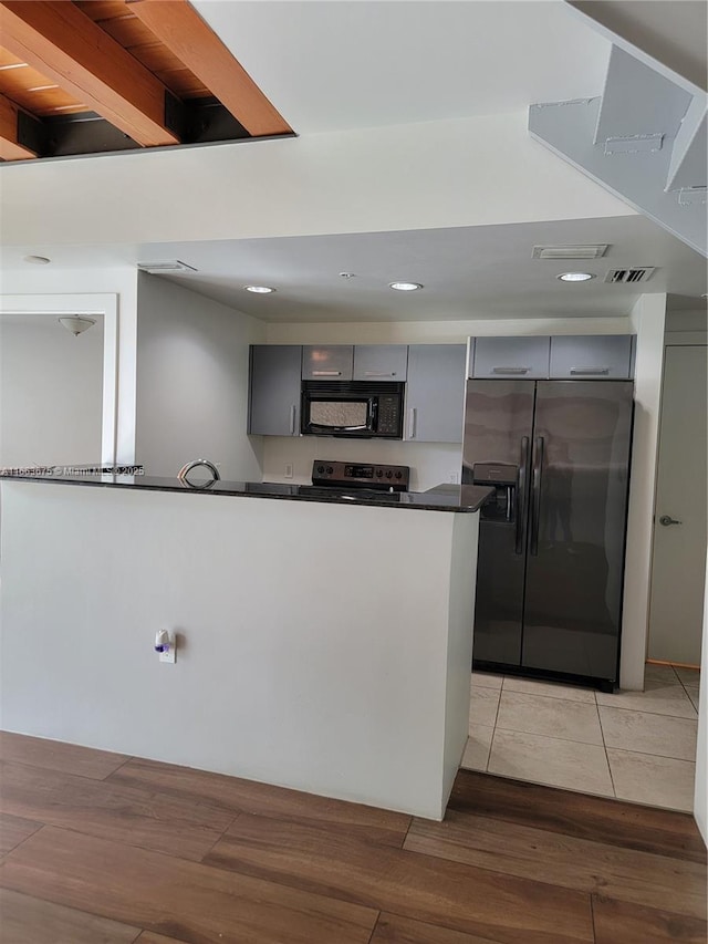 kitchen with stainless steel appliances, gray cabinets, and light wood-type flooring