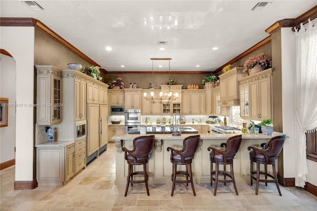 kitchen featuring a kitchen breakfast bar, cream cabinetry, kitchen peninsula, and stainless steel appliances