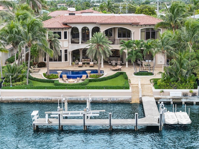 back of house featuring a water view and a patio area