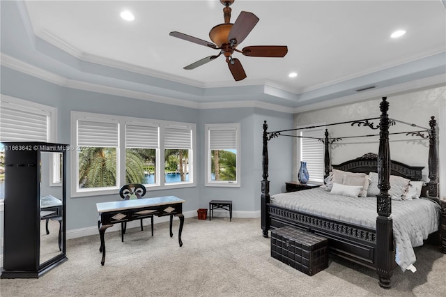 bedroom with light carpet, a tray ceiling, ceiling fan, and crown molding