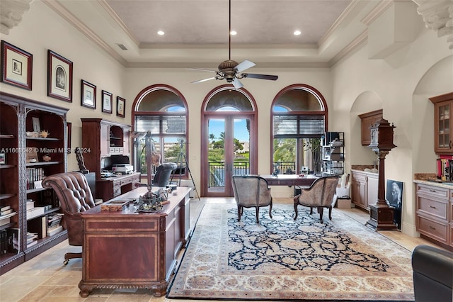 home office featuring ornamental molding, a high ceiling, a tray ceiling, and ceiling fan