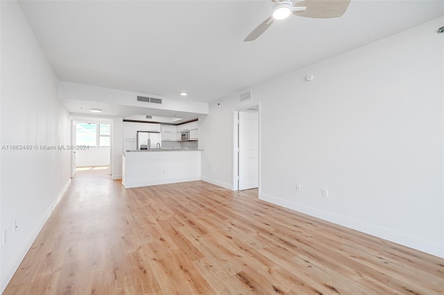 unfurnished living room with light hardwood / wood-style flooring and ceiling fan