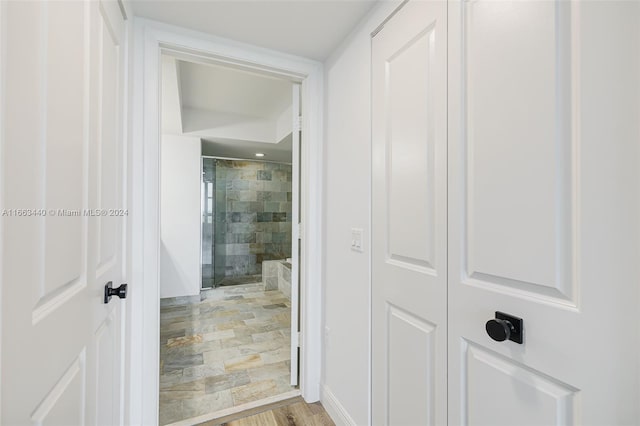 bathroom with wood-type flooring and a shower with shower door