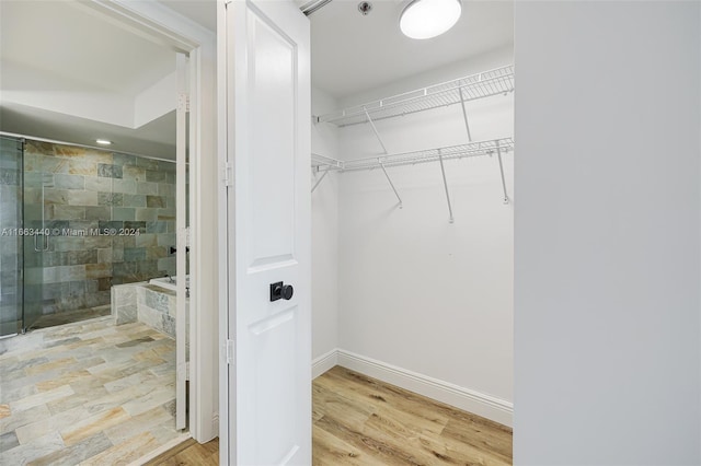 spacious closet featuring light hardwood / wood-style floors