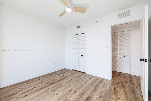 unfurnished bedroom with a closet, light wood-type flooring, and ceiling fan