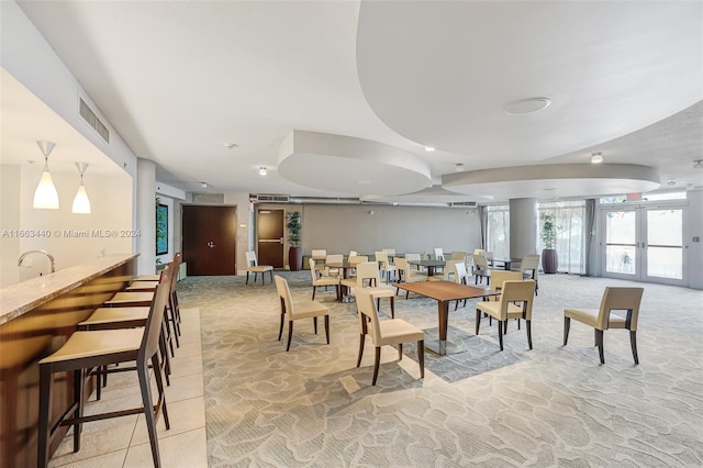 dining space with light tile patterned flooring and french doors