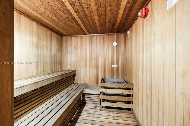 view of sauna / steam room with wood-type flooring, wood ceiling, and wooden walls