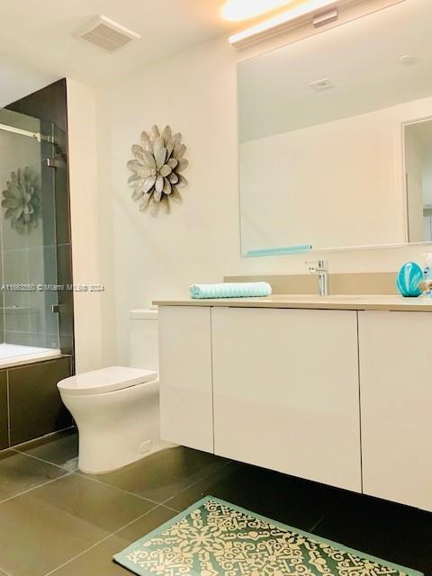 full bathroom with vanity, combined bath / shower with glass door, toilet, and tile patterned floors