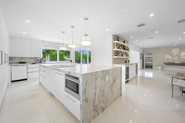 kitchen featuring decorative light fixtures, wall oven, a large island, black electric stovetop, and white cabinetry