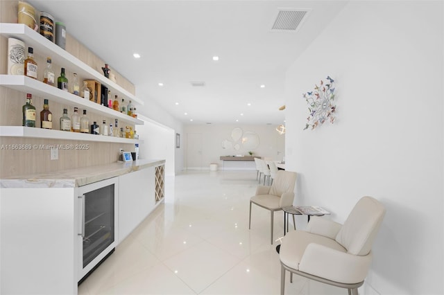 bar featuring beverage cooler and light tile patterned floors