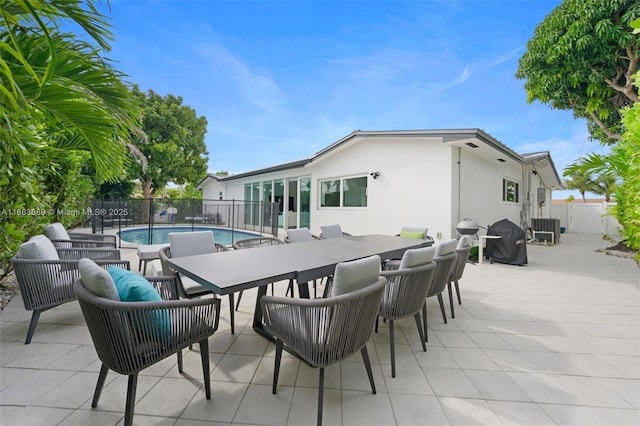 exterior space featuring a patio, central air condition unit, and a fenced in pool