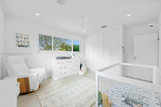 bedroom featuring a nursery area, a closet, and ceiling fan