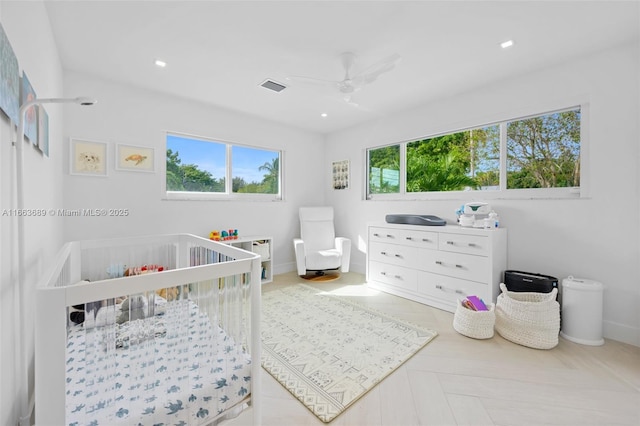 bedroom with ceiling fan and a crib