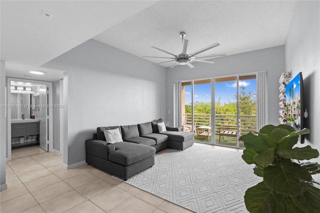 tiled living room with a textured ceiling and ceiling fan