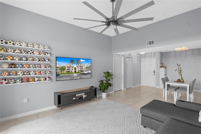 tiled living room with ceiling fan with notable chandelier