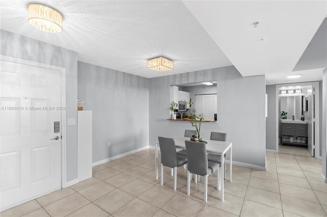 dining area featuring light tile patterned floors and an inviting chandelier