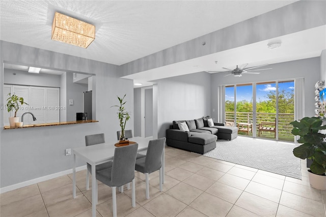 tiled dining space with ceiling fan and sink