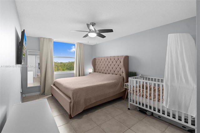 tiled bedroom featuring a textured ceiling and ceiling fan