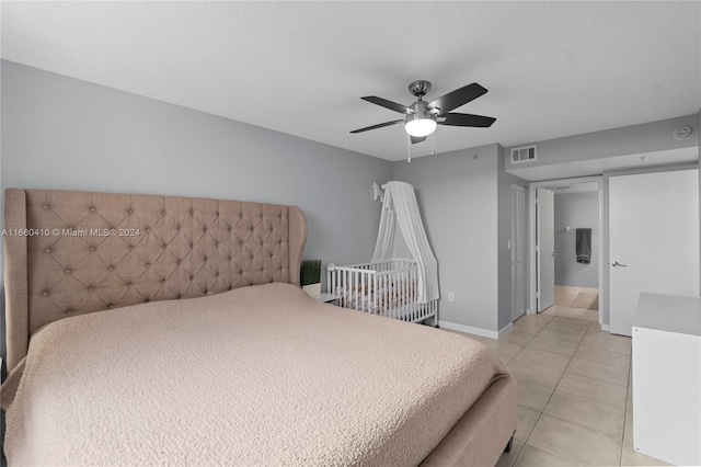 tiled bedroom featuring ceiling fan