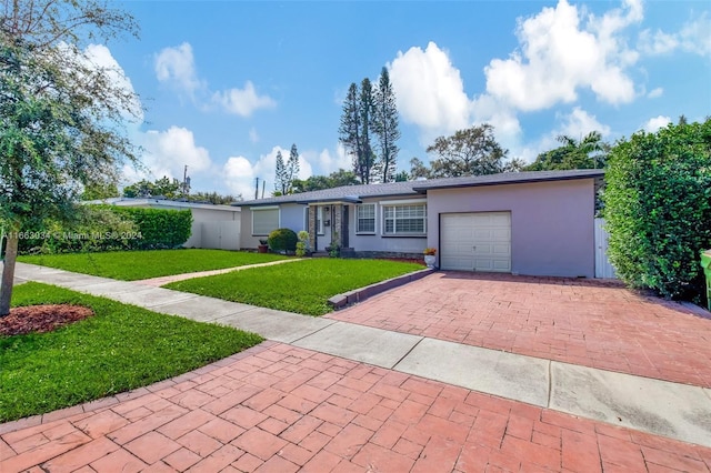 540 NE 142nd St, North Miami, FL 33161 - ranch-style home with a garage, decorative driveway, stucco siding, and a front lawn