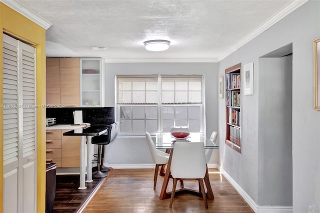 home office with ornamental molding and dark hardwood / wood-style flooring