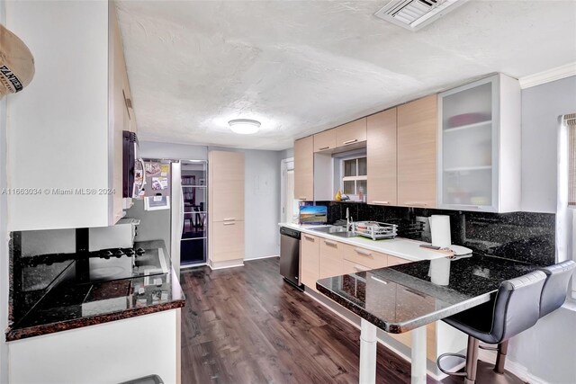 540 NE 142nd St, North Miami, FL 33161 - kitchen featuring appliances with stainless steel finishes, decorative backsplash, a peninsula, dark wood-style flooring, and a kitchen bar