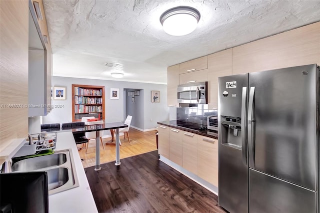 kitchen featuring dark hardwood / wood-style floors, sink, decorative backsplash, stainless steel appliances, and ornamental molding