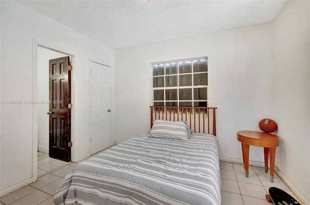 540 NE 142nd St, North Miami, FL 33161 - tiled bedroom with a textured ceiling and baseboards