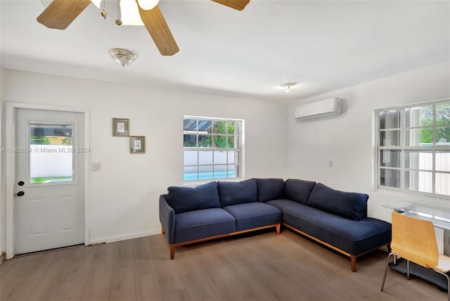 living room featuring wood-type flooring, a wall mounted AC, and ceiling fan