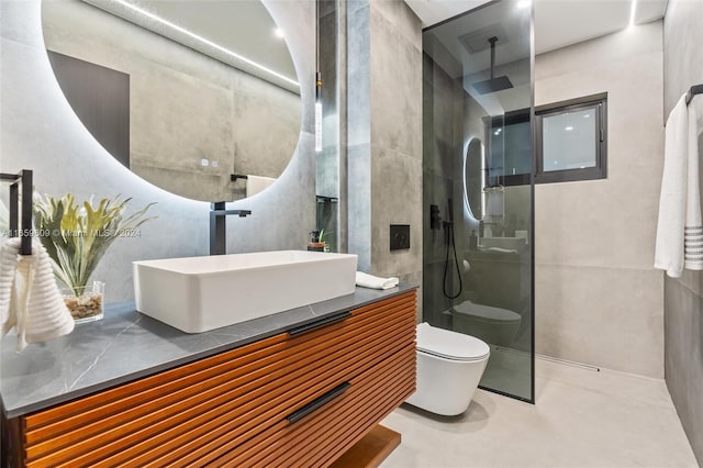 bathroom with tiled shower, vanity, and toilet