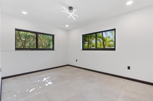 unfurnished room featuring a chandelier and a wealth of natural light