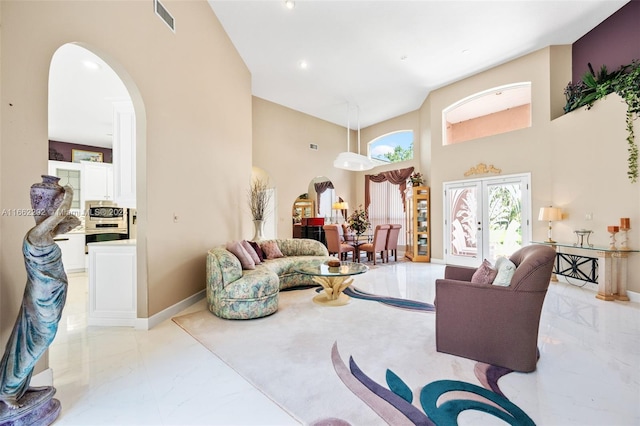 living room featuring french doors and a high ceiling