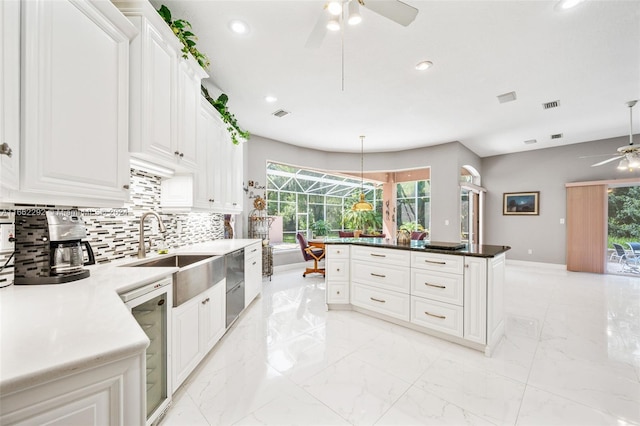 kitchen featuring tasteful backsplash, hanging light fixtures, white cabinets, and beverage cooler