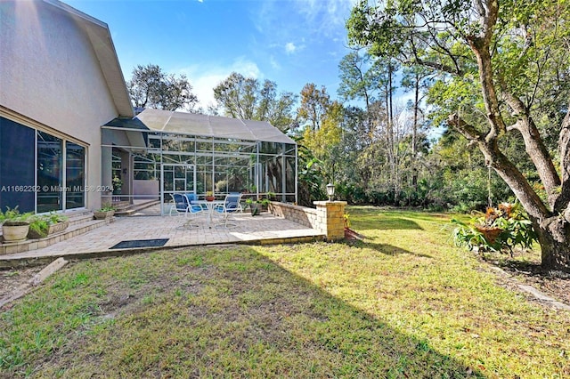 view of yard with glass enclosure and a patio area