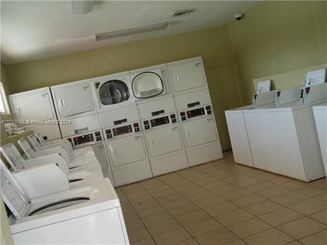 clothes washing area with light tile patterned flooring, stacked washer and dryer, and independent washer and dryer