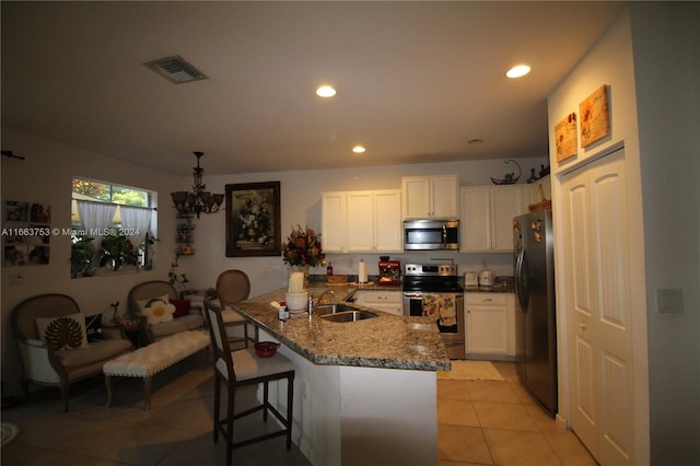 kitchen featuring a breakfast bar, white cabinetry, kitchen peninsula, stainless steel appliances, and light tile patterned floors