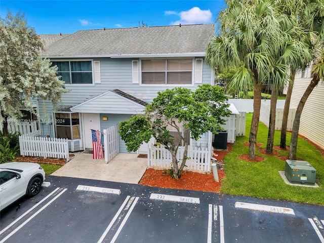 view of front of property featuring central AC unit and a front yard