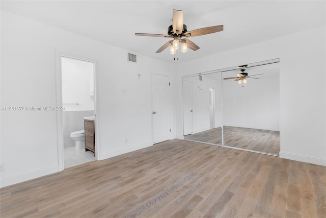 unfurnished bedroom featuring light hardwood / wood-style flooring, connected bathroom, and ceiling fan