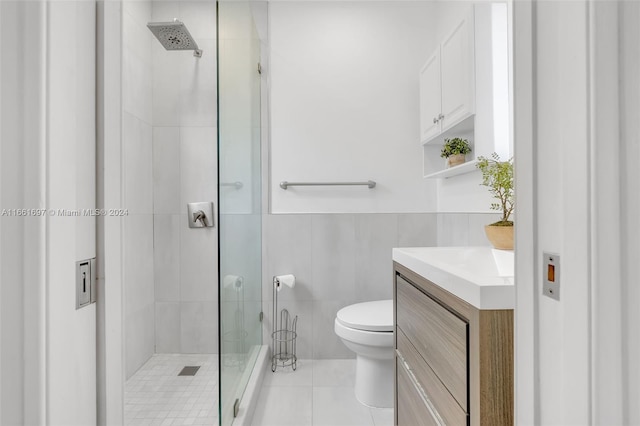 bathroom featuring tile walls, tile patterned floors, a shower with shower door, vanity, and toilet