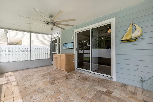 unfurnished sunroom with ceiling fan