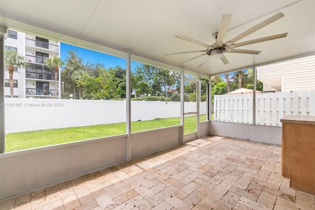 unfurnished sunroom with ceiling fan