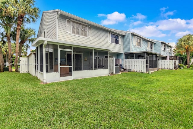 back of property with a lawn and a sunroom