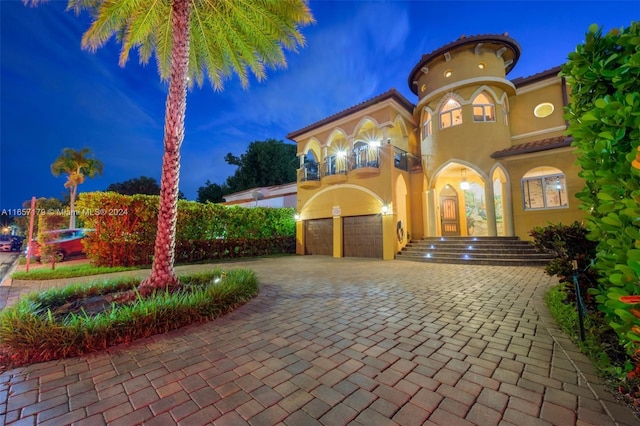 9580 Byron Ave, Surfside, FL 33154 - mediterranean / spanish-style home featuring stucco siding, decorative driveway, a garage, and a balcony
